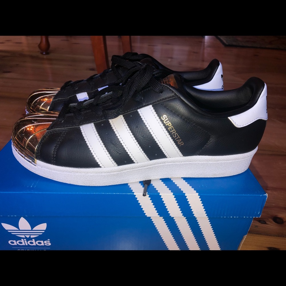 COPY - Black with gold toe adidas superstar sneakers.